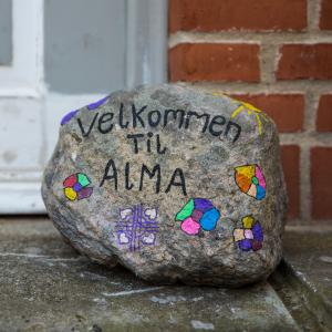 Sten med teksten "Velkommen til Alma"