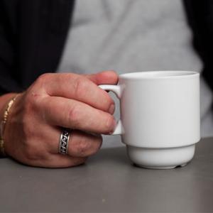 Kvindehånd med hvid kaffekop 