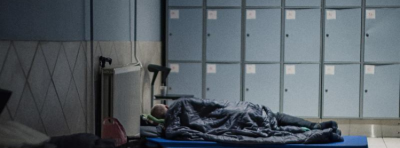 En mand ligger i sin sovepose og sover i en af Kirkens Korshærs natvarmestuer
