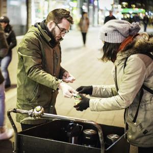 medarbejder giver suppe til kvinde på gaden